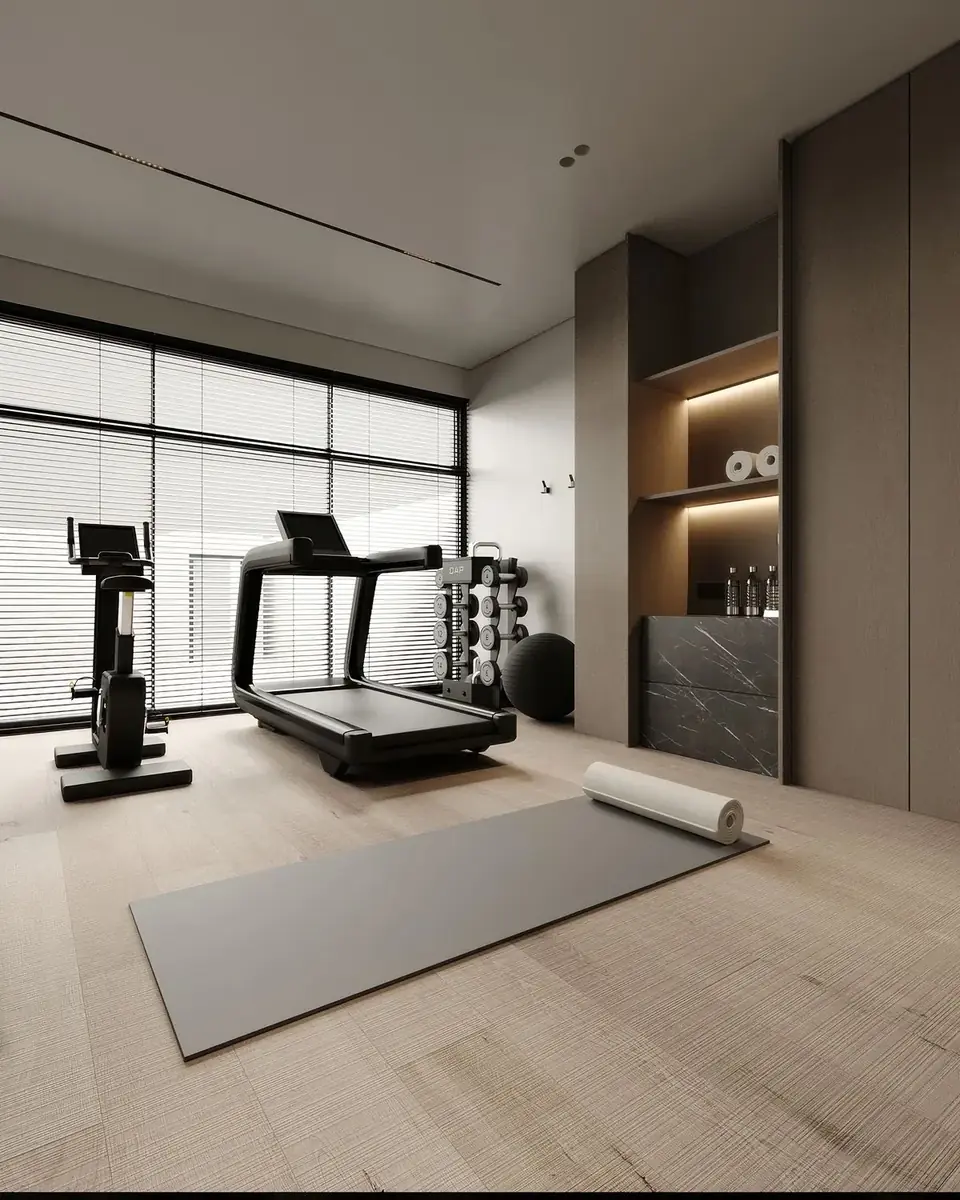 Salle de sport privée lumineuse : parquet clair, tapis de course, vélo, rack d'haltères, niche rétroéclairée et meuble en marbre noir intégrés à la menuiserie