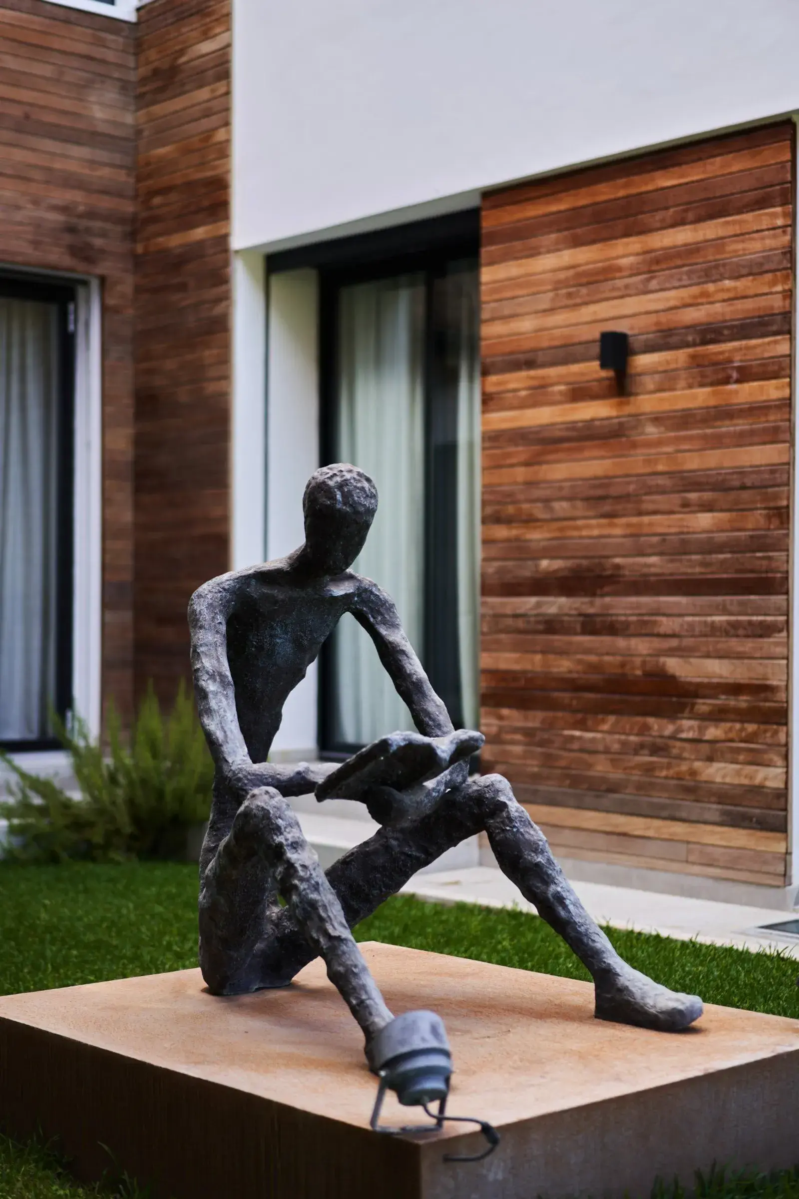 Sculpture en bronze d'un lecteur sur socle en acier corten, jardin