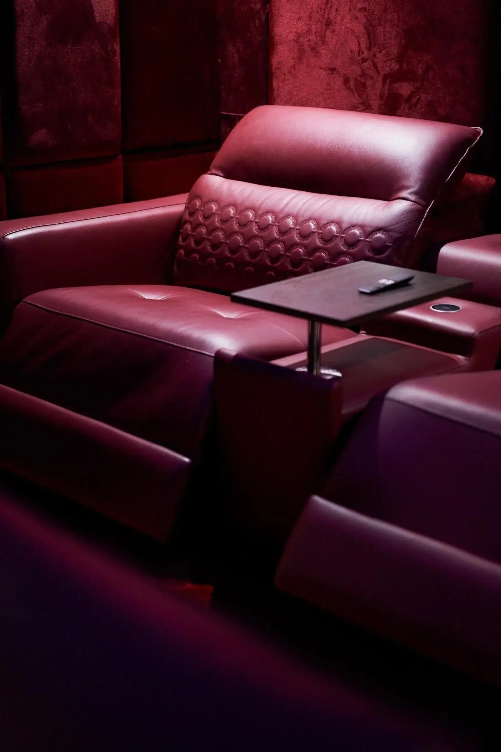 Home cinéma : murs en velours bordeaux et fauteuils italiens en cuir, son Dolby Atmos